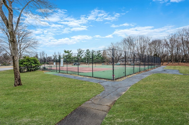 view of sport court featuring a lawn and fence