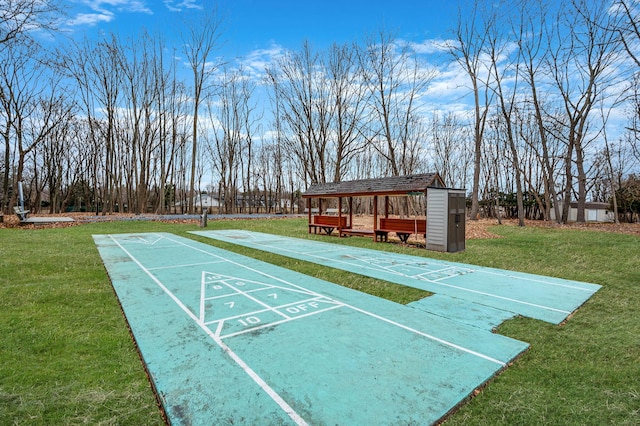 view of home's community with shuffleboard and a lawn