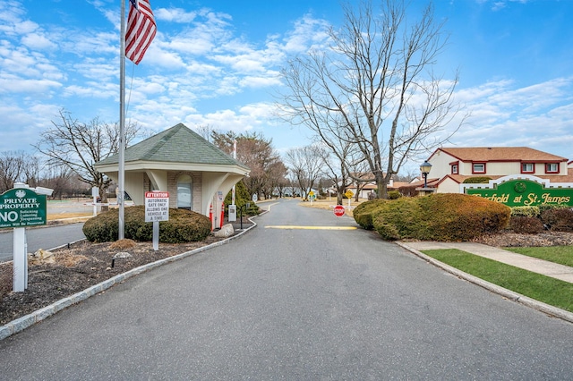 view of street featuring curbs, a gated entry, and traffic signs