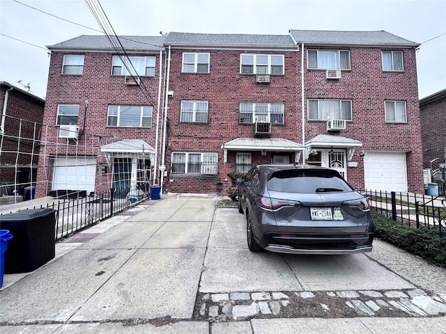 view of front of property featuring brick siding, fence, and central air condition unit