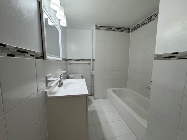 full bath with tile walls, vanity, and tile patterned floors