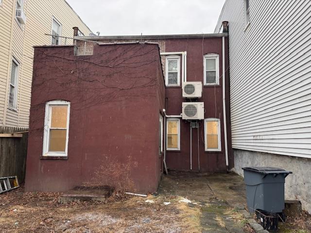 view of side of property with ac unit, fence, and stucco siding