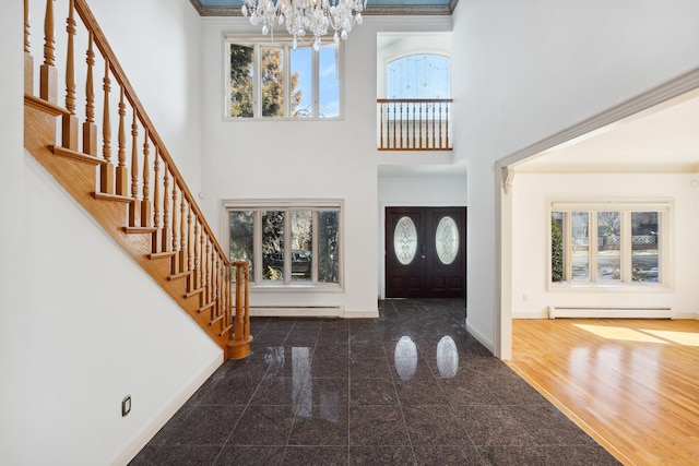 entryway featuring baseboards, stairway, a high ceiling, baseboard heating, and granite finish floor