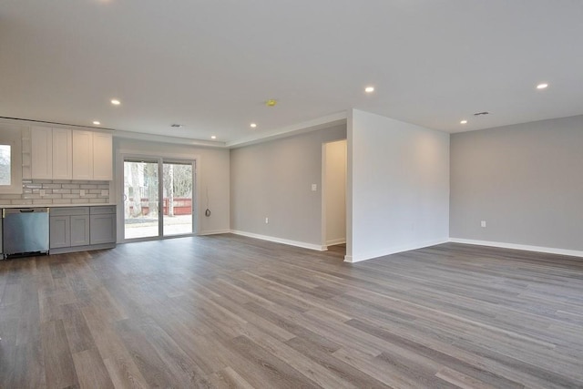 unfurnished living room featuring recessed lighting, baseboards, and wood finished floors