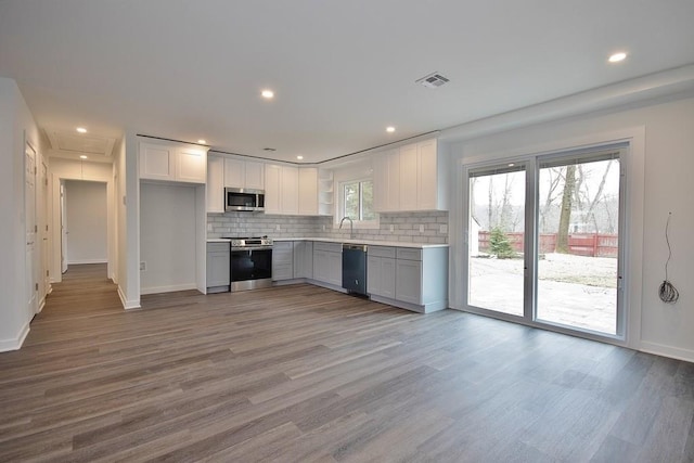 kitchen featuring light countertops, appliances with stainless steel finishes, backsplash, and visible vents