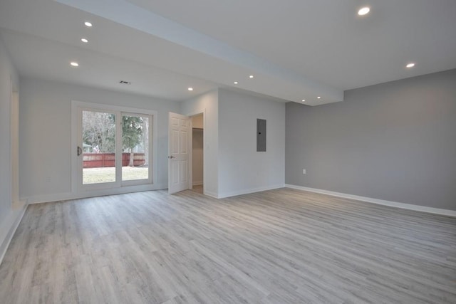 unfurnished living room featuring recessed lighting, light wood-type flooring, electric panel, and baseboards