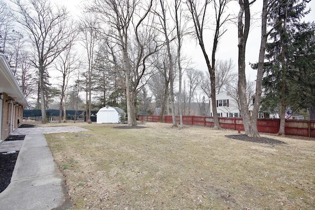 view of yard featuring a shed, an outdoor structure, and a fenced backyard