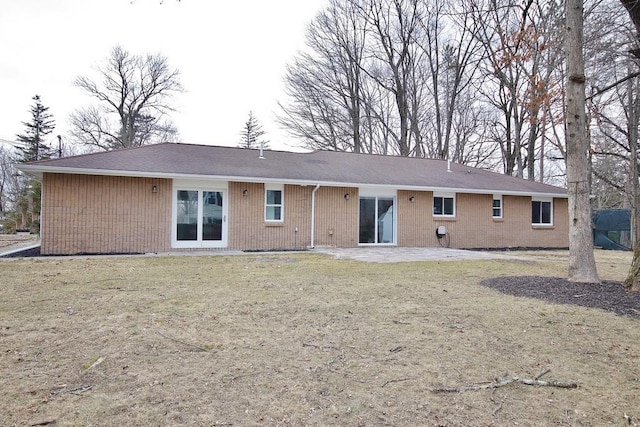 rear view of house with a lawn and a patio area