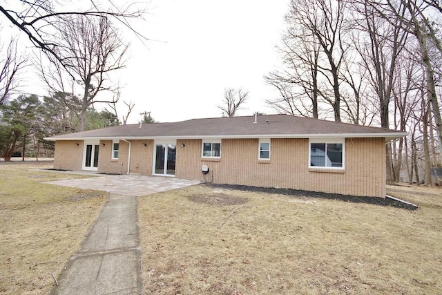 rear view of property with a patio and a lawn