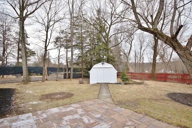 view of yard featuring a storage shed, a patio area, an outdoor structure, and a fenced backyard