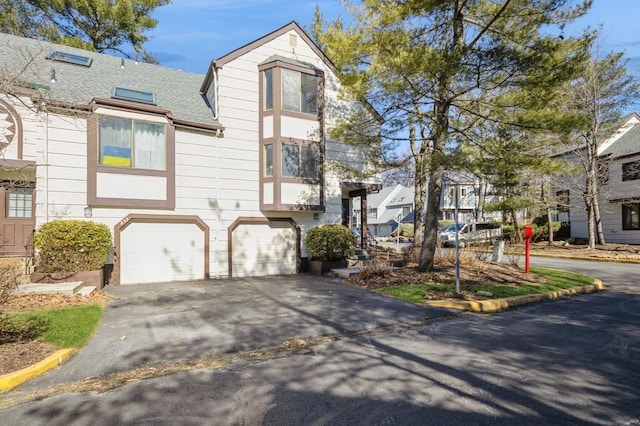 view of front of property with driveway and a shingled roof