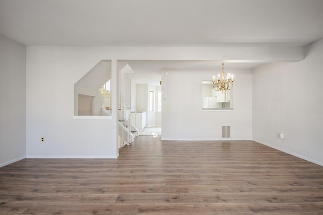 interior space with visible vents, baseboards, stairs, an inviting chandelier, and wood finished floors