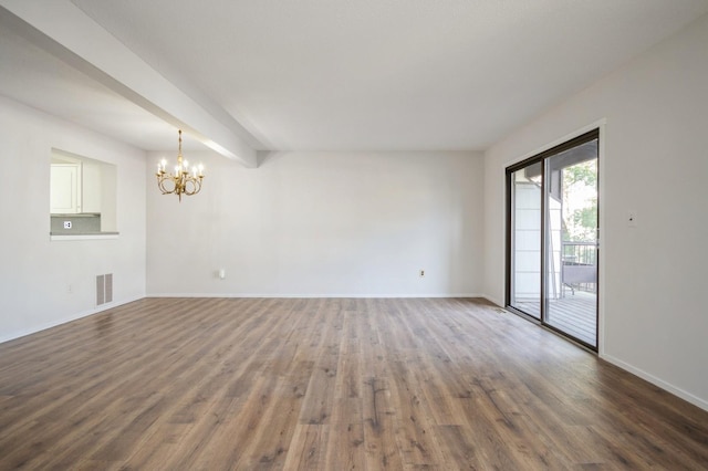 unfurnished living room with dark wood finished floors, visible vents, baseboards, and an inviting chandelier