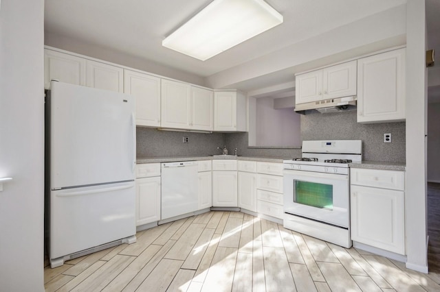 kitchen featuring under cabinet range hood, white appliances, white cabinets, and a sink