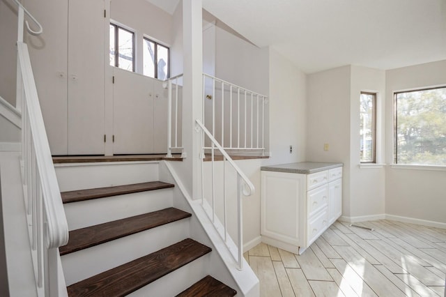 stairs featuring wood finish floors and baseboards