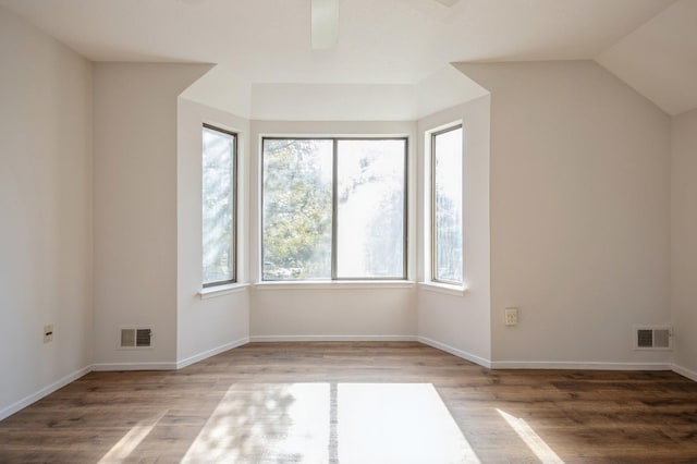 unfurnished room with visible vents, baseboards, wood finished floors, and a ceiling fan