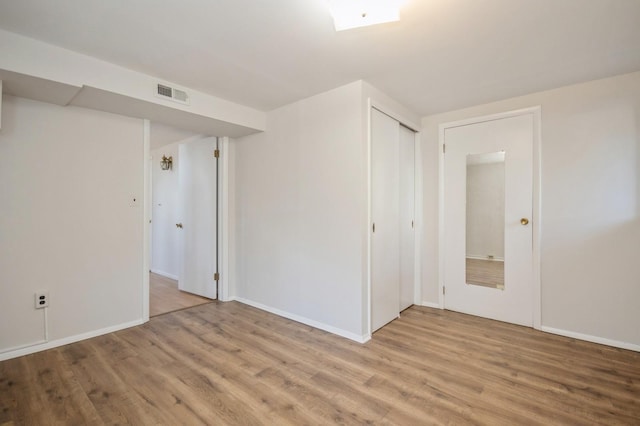 spare room featuring visible vents, baseboards, and wood finished floors