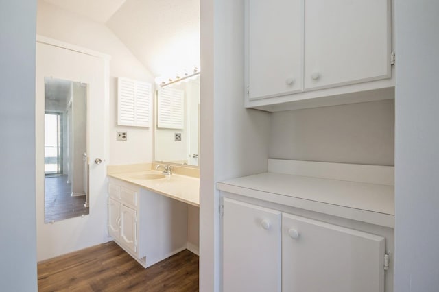 bathroom featuring wood finished floors, vanity, and vaulted ceiling