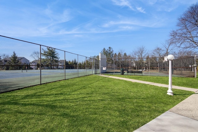 surrounding community featuring a yard, a tennis court, community basketball court, and fence