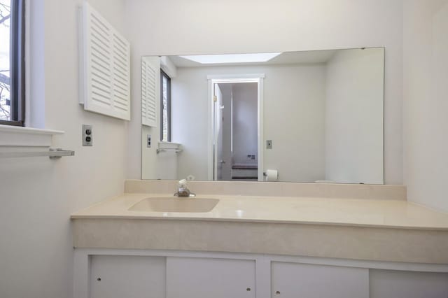 bathroom with vanity, a skylight, and toilet