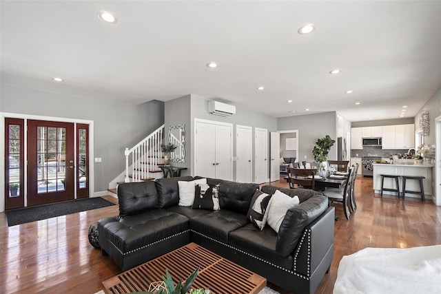 living area with recessed lighting, stairway, and wood finished floors