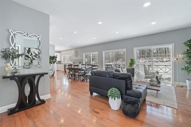 living room featuring recessed lighting, light wood-style floors, and baseboards