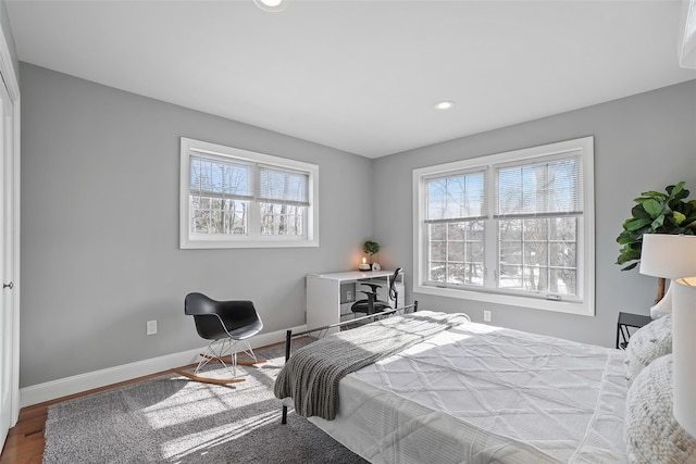 bedroom with recessed lighting, wood finished floors, and baseboards