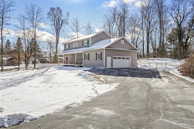 view of front of house with covered porch, a garage, and driveway