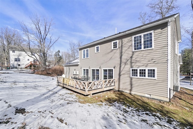 snow covered back of property with crawl space and a wooden deck