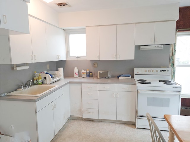 kitchen featuring white electric range, a sink, visible vents, white cabinets, and light countertops