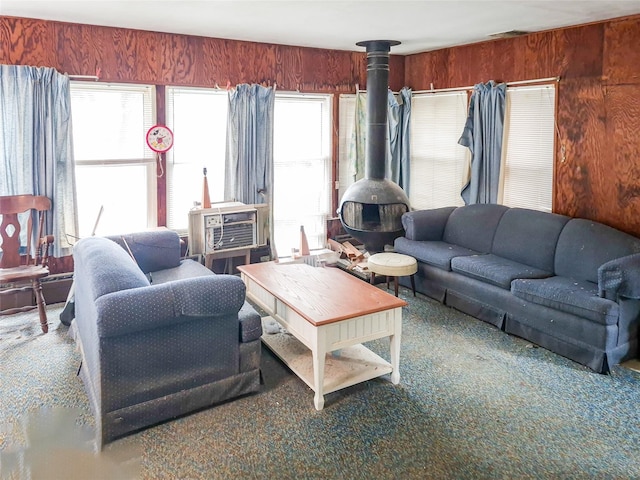 living area with cooling unit, a wood stove, and wood walls