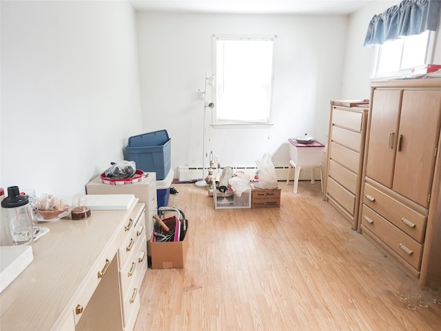 interior space with light wood finished floors and a baseboard radiator