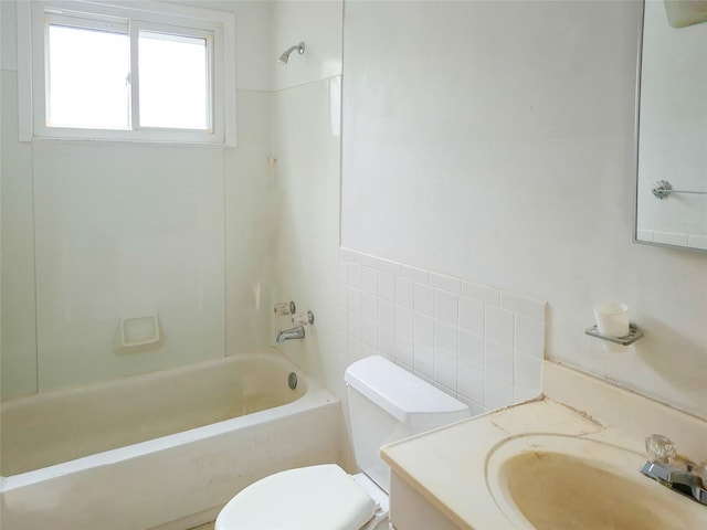 bathroom with shower / tub combination, vanity, toilet, and tile walls