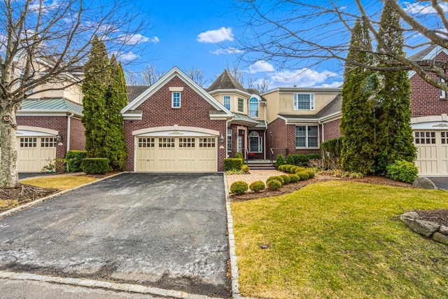 view of front of house featuring an attached garage, a front lawn, aphalt driveway, and brick siding