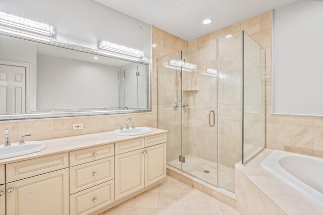 bathroom with a garden tub, a sink, and a shower stall