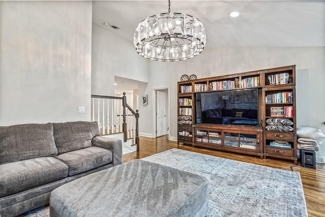 living room with visible vents, stairway, baseboards, and wood finished floors