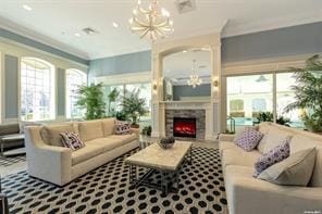 living room featuring a warm lit fireplace and a chandelier