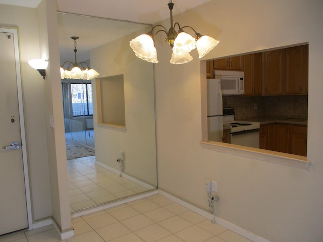 interior space featuring a chandelier, white appliances, brown cabinetry, and decorative backsplash