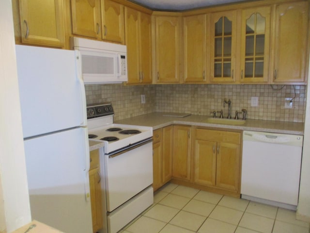 kitchen featuring light tile patterned floors, light countertops, white appliances, and a sink