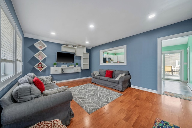 living area with recessed lighting, wood finished floors, and baseboards