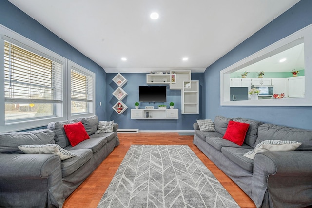 living area with light wood-type flooring, a baseboard radiator, baseboards, and recessed lighting