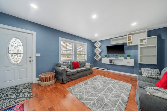 living area with a baseboard radiator, recessed lighting, baseboards, and wood finished floors