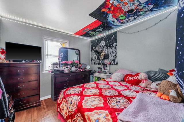 bedroom with baseboards and wood finished floors