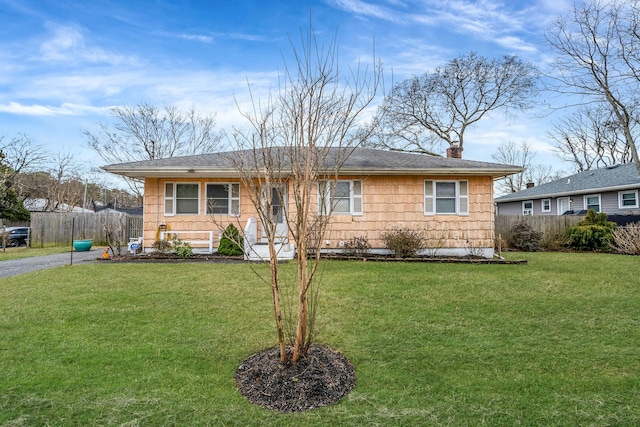 ranch-style home with a front yard, fence, and a chimney