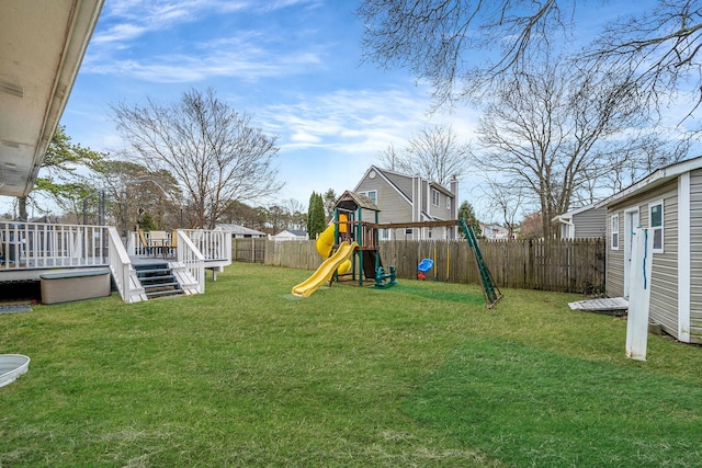 view of jungle gym featuring a lawn, a fenced backyard, and a wooden deck