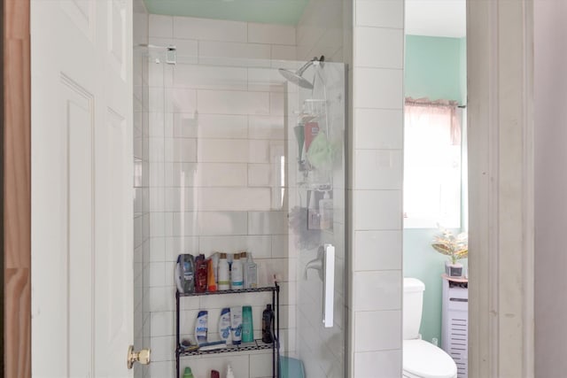 full bathroom with tiled shower and toilet