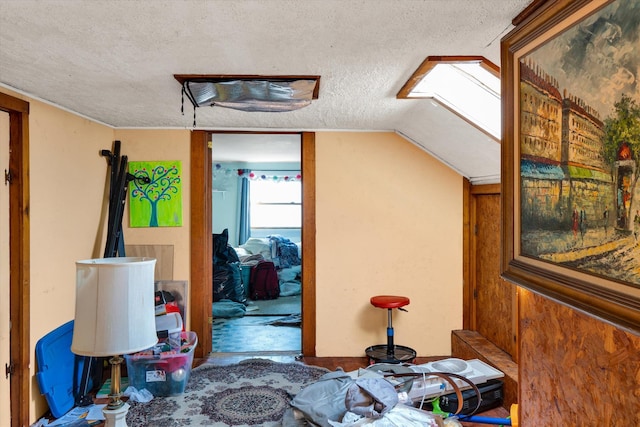 additional living space featuring a textured ceiling and lofted ceiling with skylight