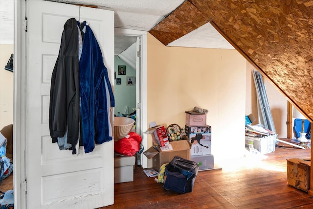 additional living space featuring a textured ceiling and hardwood / wood-style floors