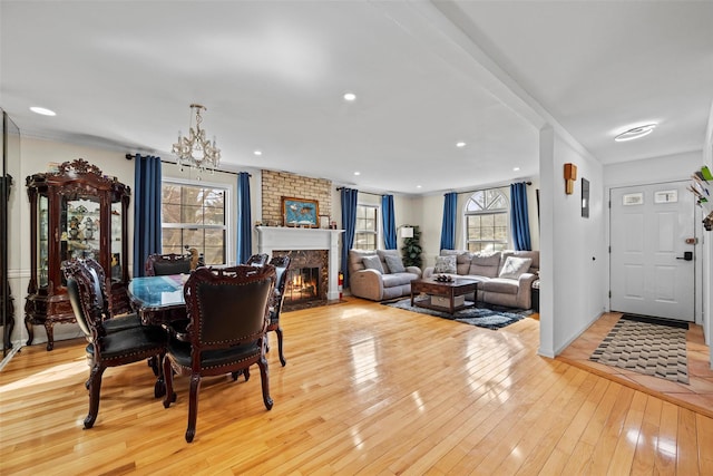 dining area featuring recessed lighting, a brick fireplace, a wealth of natural light, and light wood-style floors