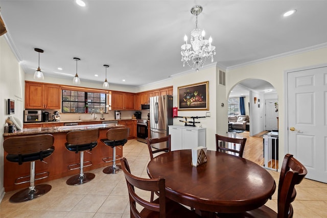 dining area featuring ornamental molding, arched walkways, recessed lighting, and light tile patterned floors